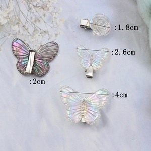 Colorful iridescent butterfly and flower hair clips set on light blue background