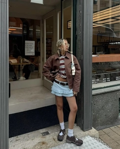 Conjunto de estilo callejero con minifalda de tablas azul y chaqueta marrón