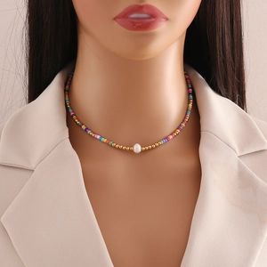 Detail of colorful seed bead necklace with natural pearl center on a mannequin