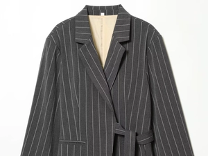 Detail of dark grey pinstripe blazer with notch lapel and matching waist tie belt