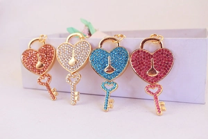 Macro detail of rhinestone heart lock keychains in gold, silver, blue, and pink colors