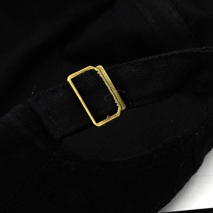 Detail of adjustable metal buckle and durable fabric strap on black military cadet cap