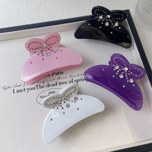 Close-up of sparkling acetate bow hair claws with rhinestones in four soft colors