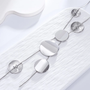 Detailed view of silver long necklace with polished and ribbed circular pendants