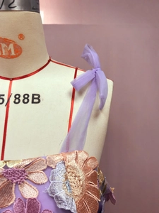Détail d'une robe en résille lavande avec broderie florale 3D et bretelles en organza