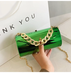Detailed close-up of green mirror acrylic cylindrical bag with chunky gold chain handles