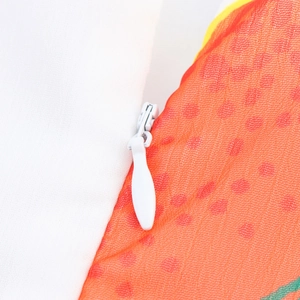 Vue macro d'une fermeture éclair invisible blanche sur une robe d'été en maille orange
