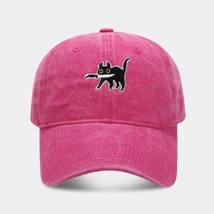 Macro detail of cartoon cat embroidery on pink washed cotton baseball cap with distressed finish