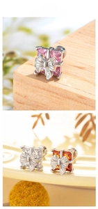 Macro view of zircon gift box earrings with metal bow and square cut crystals