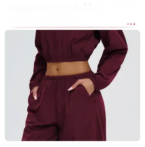 Detail of burgundy windproof hooded sports jacket with elastic cuffs and hem