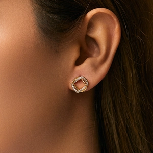 Elegant 18K gold plated leaf-shaped stud earrings with sparkling cubic zirconia on model