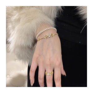 Detail of luxury iris flower bracelets and ring set worn with elegant white fur sleeve
