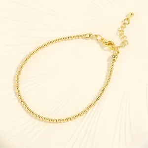 Detailed view of gold beaded bracelet with lobster clasp and adjustable extension chain