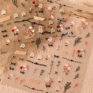 Detail of floral nail art stickers with vintage gold embossing and vanilla rose motifs