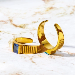 Detailed view of two gold birthstone rings featuring blue rectangular gems and ribbed texture