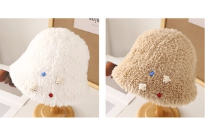 Detail of plush bucket hats in white and khaki with cute teddy bear and heart patches