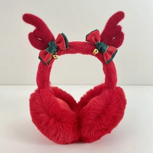 Detail of red Christmas earmuffs with plush reindeer antlers and golden bell accents