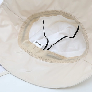 Close-up of the beige sun hat interior with mesh lining and adjustable chin strap