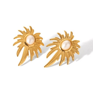 Close-up of golden vintage leaf earrings featuring central oval pearls in radial design