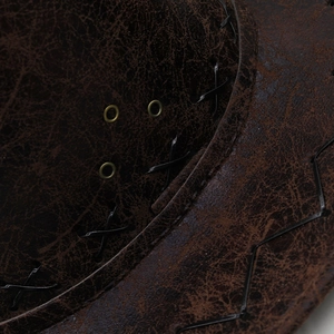 Macro view of brown cracked leather cowboy hat with cross-stitch and metal eyelets