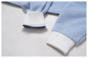 Close-up of light blue fleece jacket showing warm texture and white ribbed cuff detail