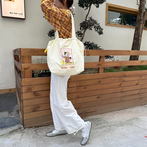 Detail of canvas tote bag with drawstring closure and cute cartoon cat illustration print