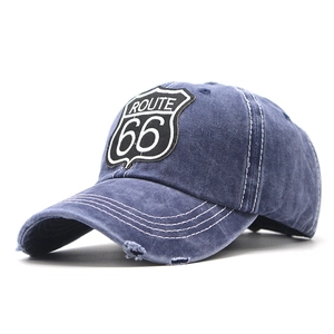 Detailed macro view of Route 66 embroidery and distressed brim on navy denim baseball cap