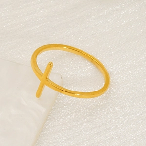 Detailed 45-degree angle of a minimalist gold cross ring with polished thin band finish