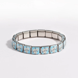 Detail of stainless steel modular link featuring a blue enamel floral pattern and stamp