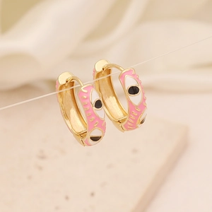 Macro view of 18K gold evil eye earrings with pink enamel and polished finish