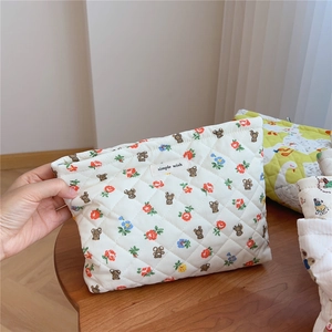 Quilted cotton makeup bag with cute bear pattern and floral design being held