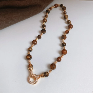 Detailed close-up of tiger eye stone beads with gold plated accents and crystal clasp