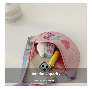 Pink kids crossbody bag showing interior capacity with glitter love patches and rainbow strap