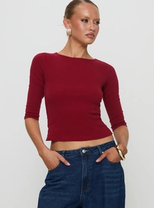 Detail of dark red ribbed knit fabric on a slim-fit crew neck top with five-point sleeves