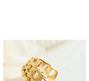Macro shot of gold-plated wide band ring with intricate vintage hollow filigree texture