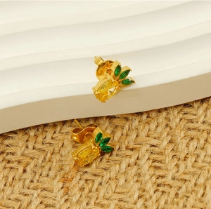Detail of pineapple studs with gold base, yellow crystals and green leaf stones