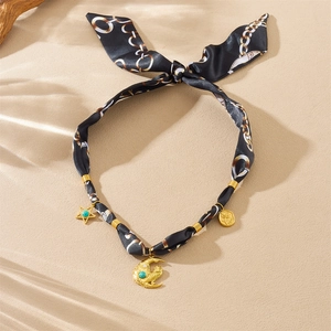 Close-up of leopard print silk scarf with golden moon, star, and rose charms