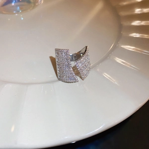 Macro shot of silver geometric ring with shimmering trapezoid zircons on ceramic tray