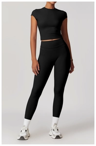 Vista completa del set yoga nero con leggings a vita alta e top sportivo corto