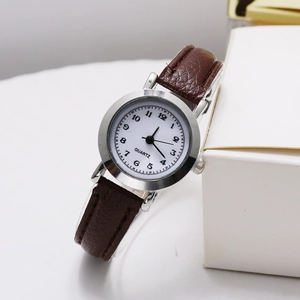 Close-up of retro quartz watch featuring white dial with Arabic numerals and brown leather strap