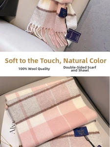 Détail d'une écharpe à carreaux rose et blanc 100% laine avec pompons et texture tissée