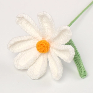 Detailed view of handmade crocheted daisy with white petals and orange center