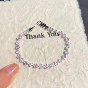 Elegant silver bracelet featuring pink and clear zircon crystals with folding clasp closure