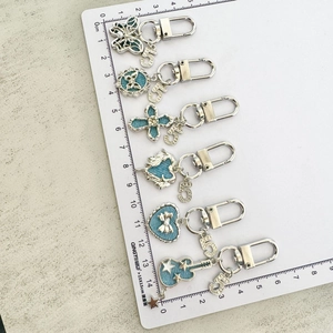 Detailed set of silver alloy keychain charms featuring denim fabric inserts and numeric pendants