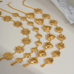 Three gold layered bracelets with sun disk, heart, and shell charms on white background
