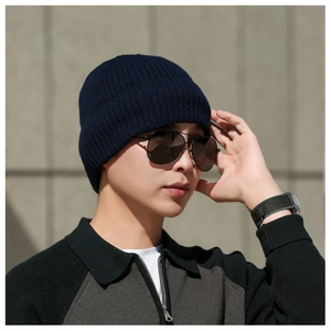 Close-up of men's dark blue ribbed knit beanie with thick fleece lining for winter outdoor use