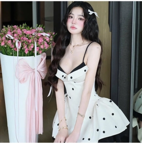 Détail d'une mini robe à pois de style français avec taille ajustée et jupe à volants