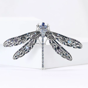 Detailed macro view of dragonfly brooch featuring blue and purple rhinestones