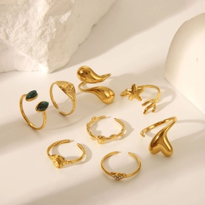 Set di otto anelli dorati con design a stella marina e cuore con gemme verdi lucide