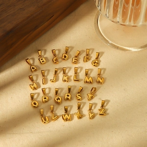 Set of 26 18k gold plated stainless steel bubble letter charms on beige fabric
